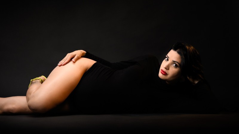 Elegant maternity photo with dramatic lighting and confident pose