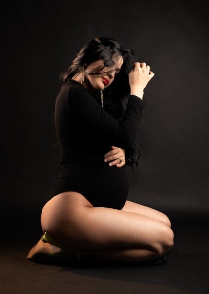 Emotional maternity portrait with soft expression and kneeling pose
