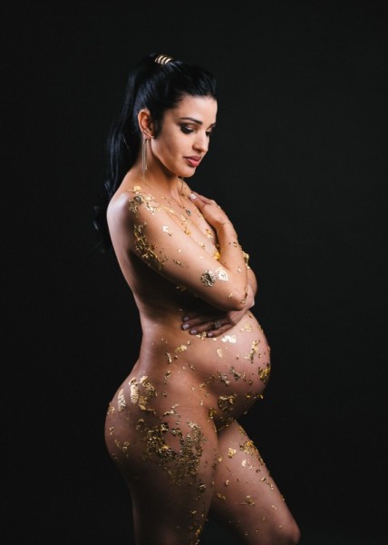 Artistic maternity photo with gold leaf and graceful profile pose