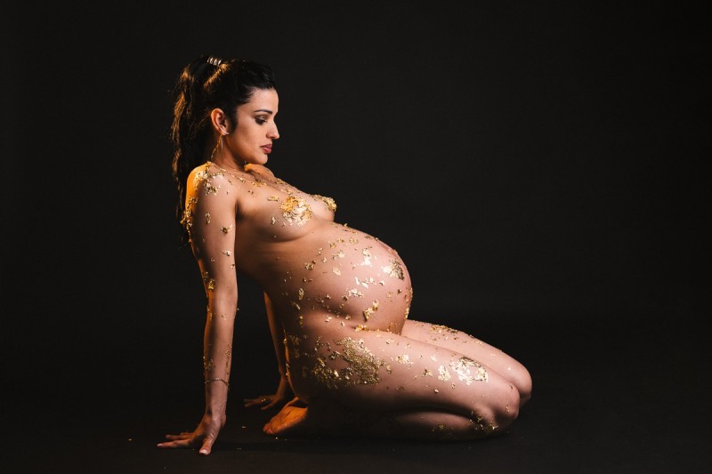 Elegant maternity photo with gold leaf in kneeling pose