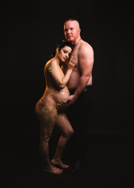 Tender maternity photo of couple with gold leaf in studio